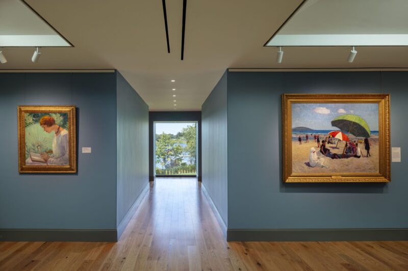 Two paintings on the walls of the Westerly Museum of American Impressionism surround a picture window witha view of the water.