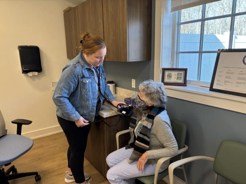 A nurse takes a blood pressure reading from a patient.