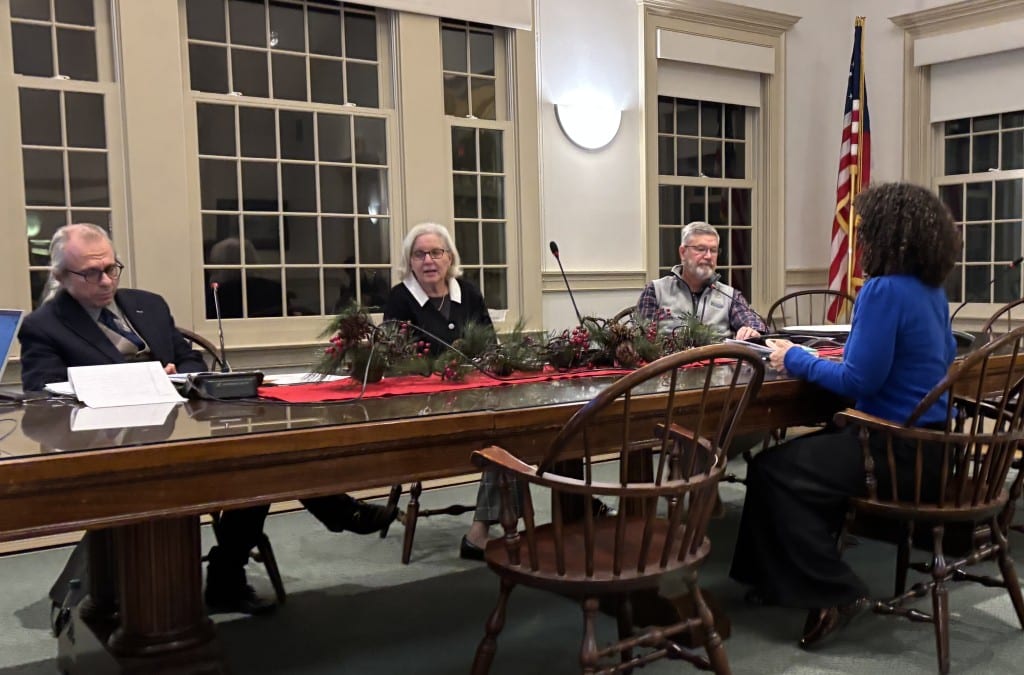 The three selectmen hear from Assessor Melinda Kronfeld at the table in the Town Hall.