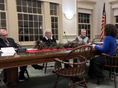 The three selectmen hear from Assessor Melinda Kronfeld at the table in the Town Hall.