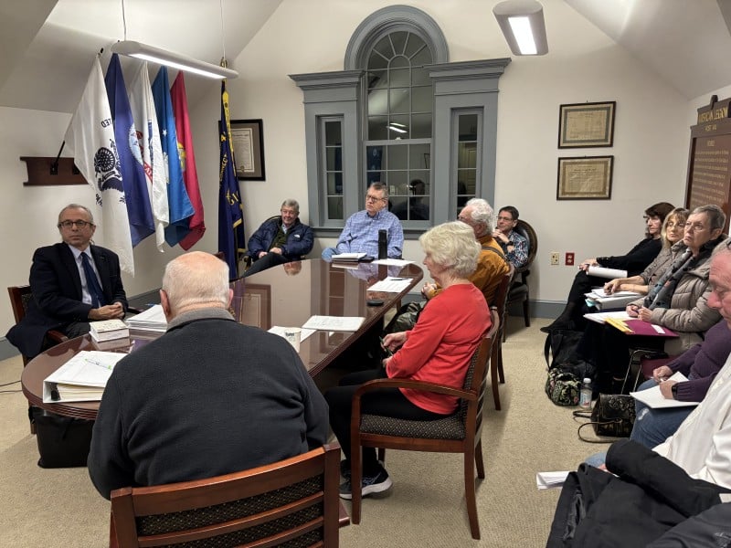 Members of the Old Lyme Water Pollution Control Authority (WPCA), as well as Selectman Jim Lampos, sit around a table and in chairs along the wall at the WPCA meeting.