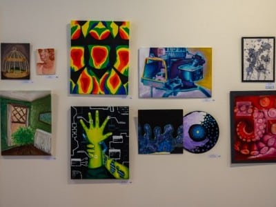 Nine paintings are shown on a wall at the 2025 Future Choices show.