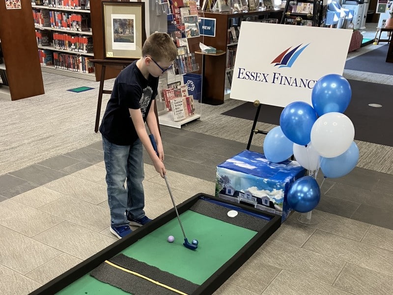 A young boy plays a hole in a section of the course sponsored by Essex Financial.