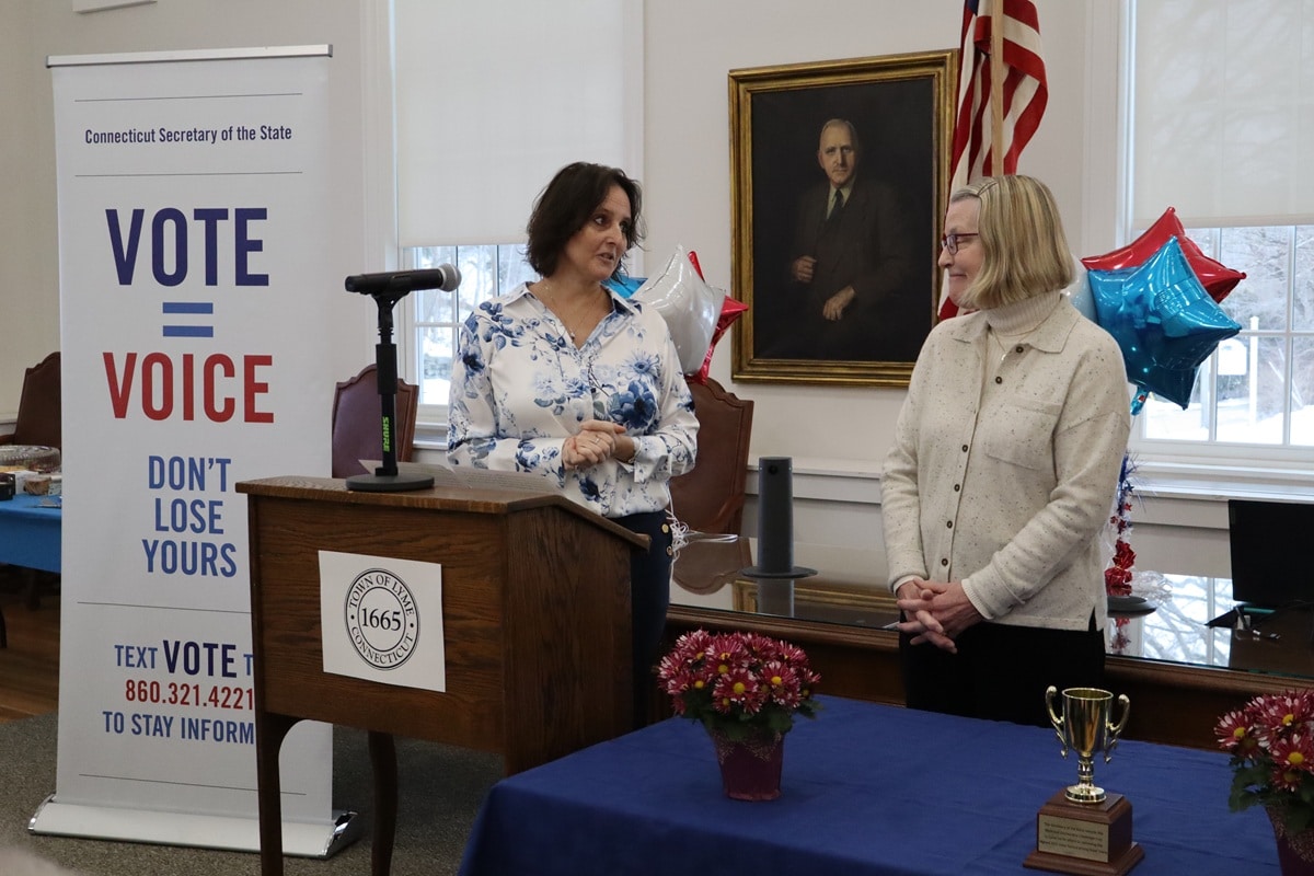 Wells looks at Davies as both women stand at the podium.