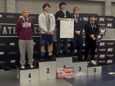 Gemme stands atop the podium holding a bracket poster in the middle of the top five finishers.