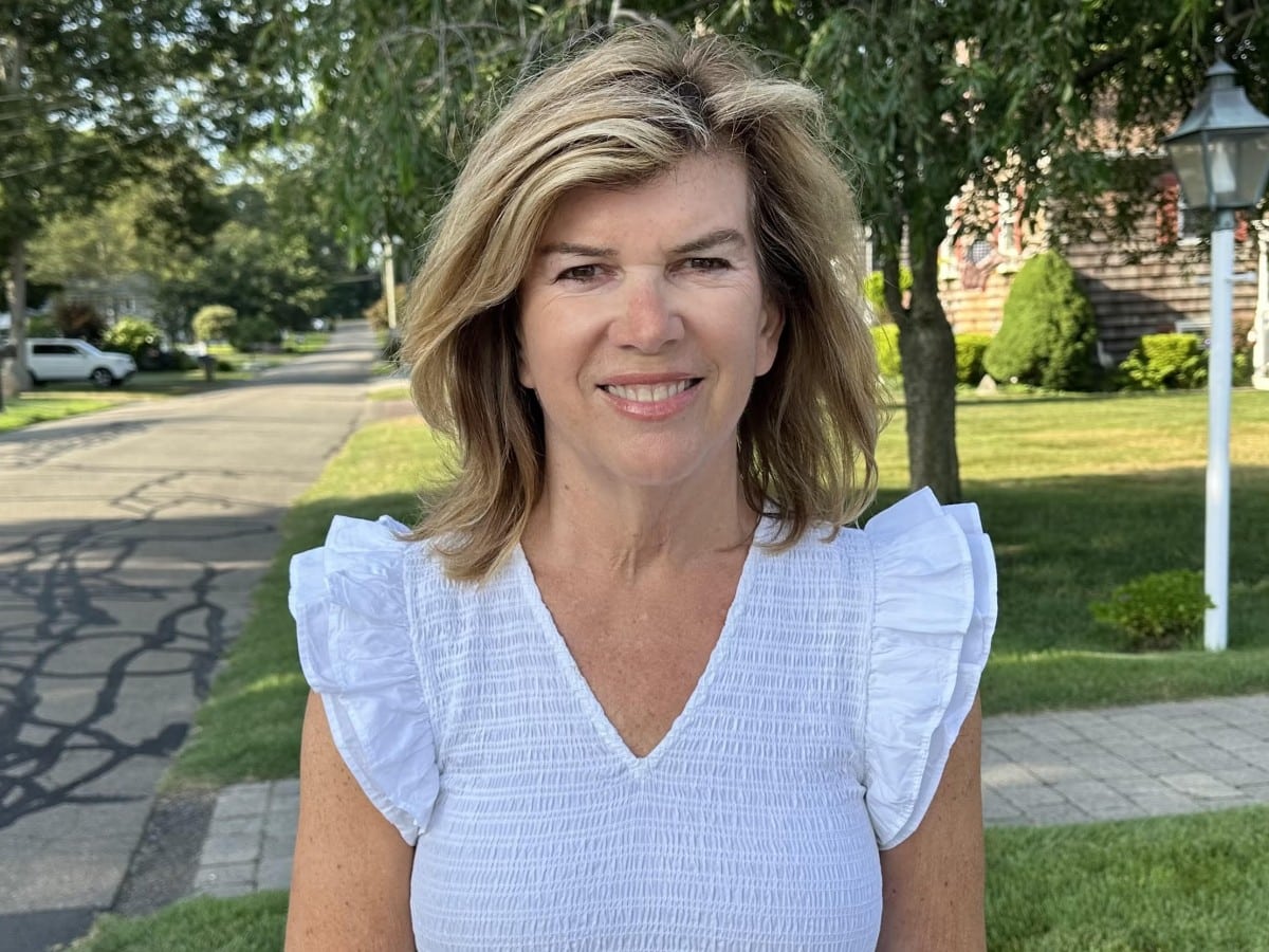 Barbara Labriola poses for a campaign photo on a leafy neighborhood street.