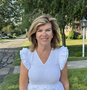 Barbara Labriola poses for a campaign photo on a leafy neighborhood street.