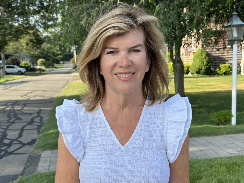 Barbara Labriola poses for a campaign photo on a leafy neighborhood street.