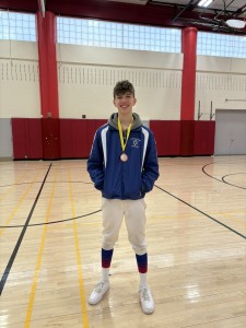 Cameron Russell poses while wearing his medal in a gymnasium.