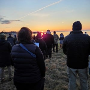 People gather on the grass in Griswold Point overlooking the water.