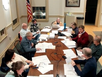 Members sit around a large table at the front of the Old Lyme Town Hall meeting room.