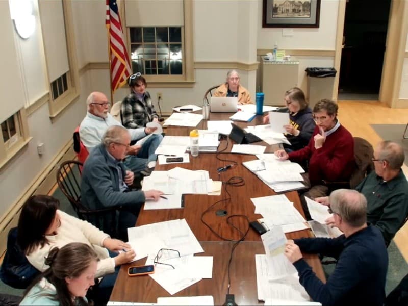 Members sit around a large table at the front of the Old Lyme Town Hall meeting room.