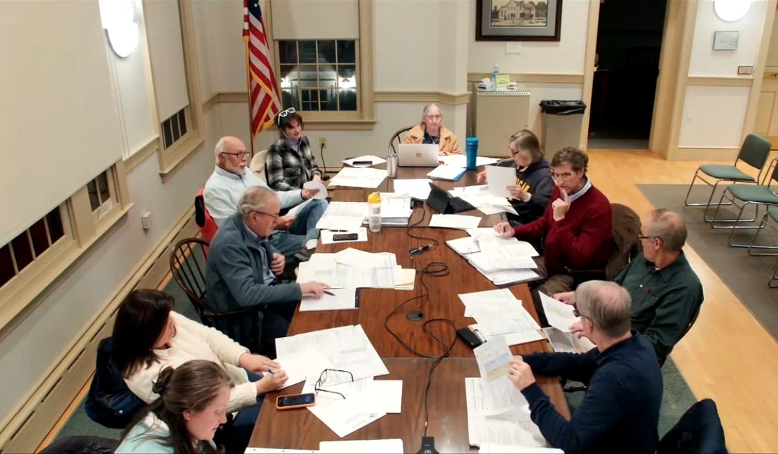 Members sit around a large table at the front of the Old Lyme Town Hall meeting room. 