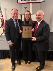 A smiling Hildie Heck holds her plaque.