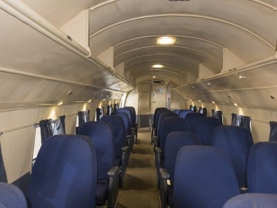 Blue seats, two to a row on one side and one per row on the other side, are shown in this interior shot of the plane.