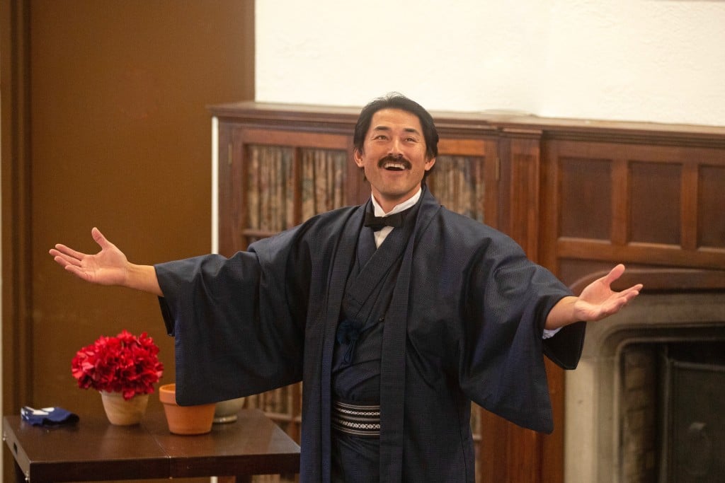 Harai stands with arms outstretched in a Japanese robe in Gillette Castle. 