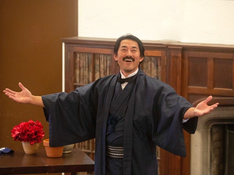Harai stands with arms outstretched in a Japanese robe in Gillette Castle.
