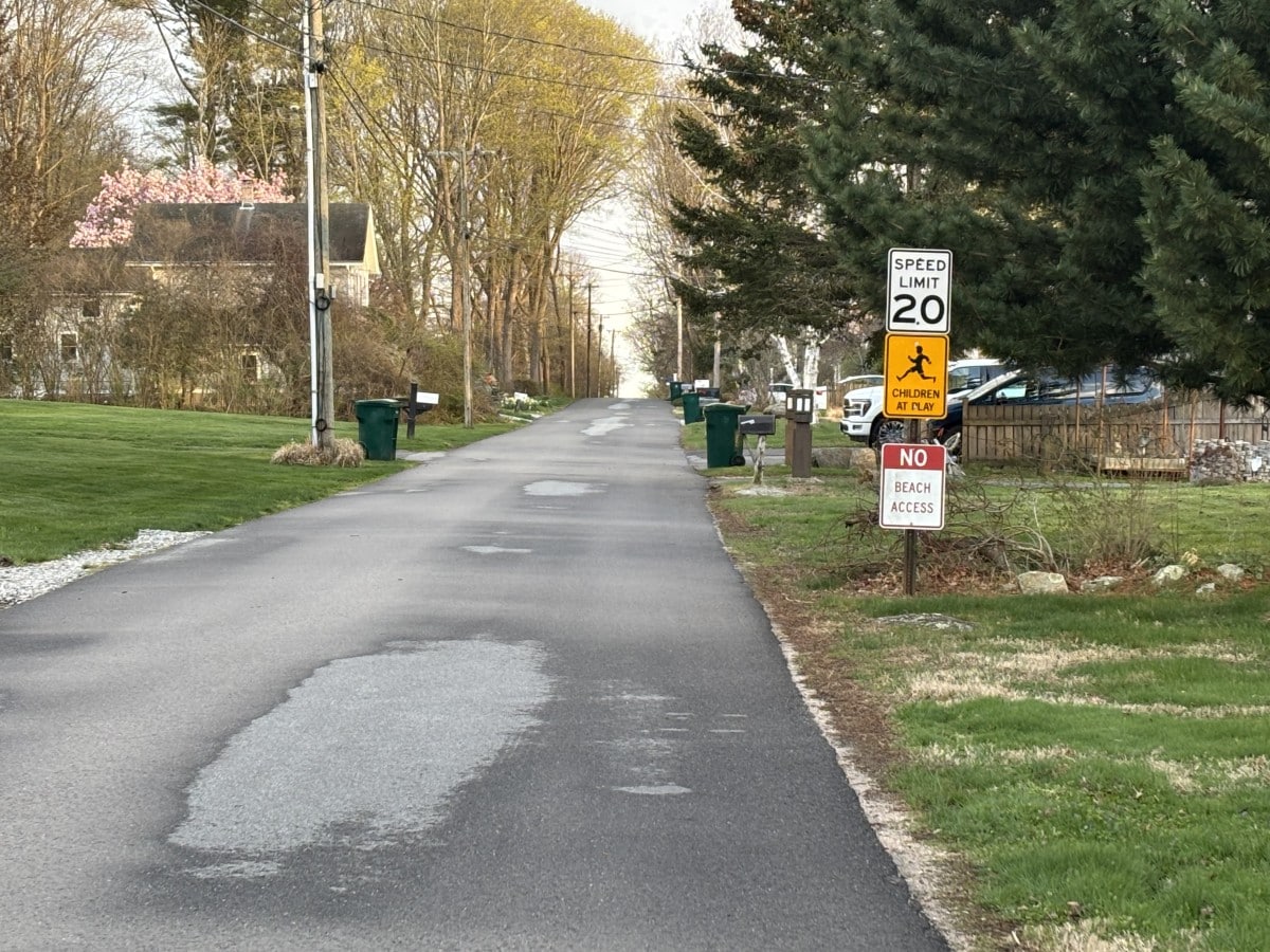 Looking at Brighton Road toward the water with a 20 mph speed limit sign, a "Children at Play" sign and a "No Beach Access" sign on the right side of the road.