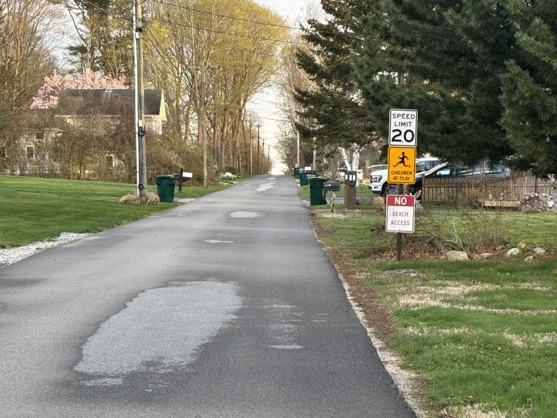 Looking at Brighton Road toward the water with a 20 mph speed limit sign, a "Children at Play" sign and a "No Beach Access" sign on the right side of the road.