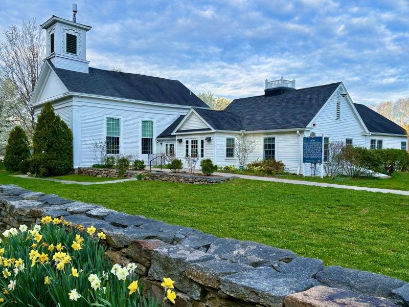 A view of the Lyme Town Hall with daffodils in the foreground.