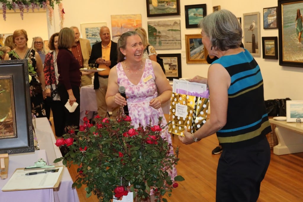 Ellsbeth Dowd laughs with a raffle winner receiving her prize.