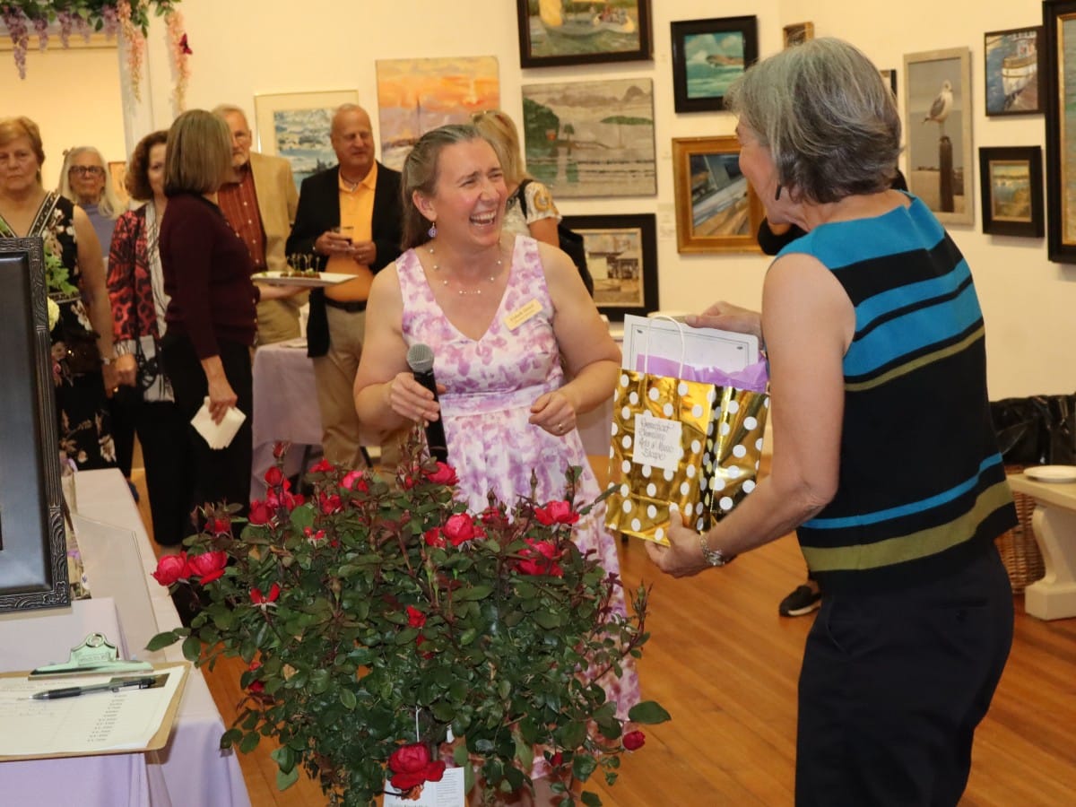 Ellsbeth Dowd laughs with a raffle winner receiving her prize.