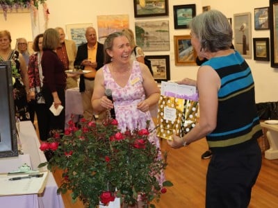 Ellsbeth Dowd laughs with a raffle winner receiving her prize.
