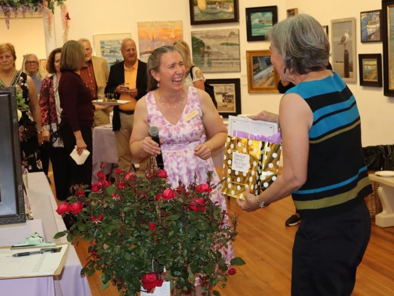 Ellsbeth Dowd laughs with a raffle winner receiving her prize.