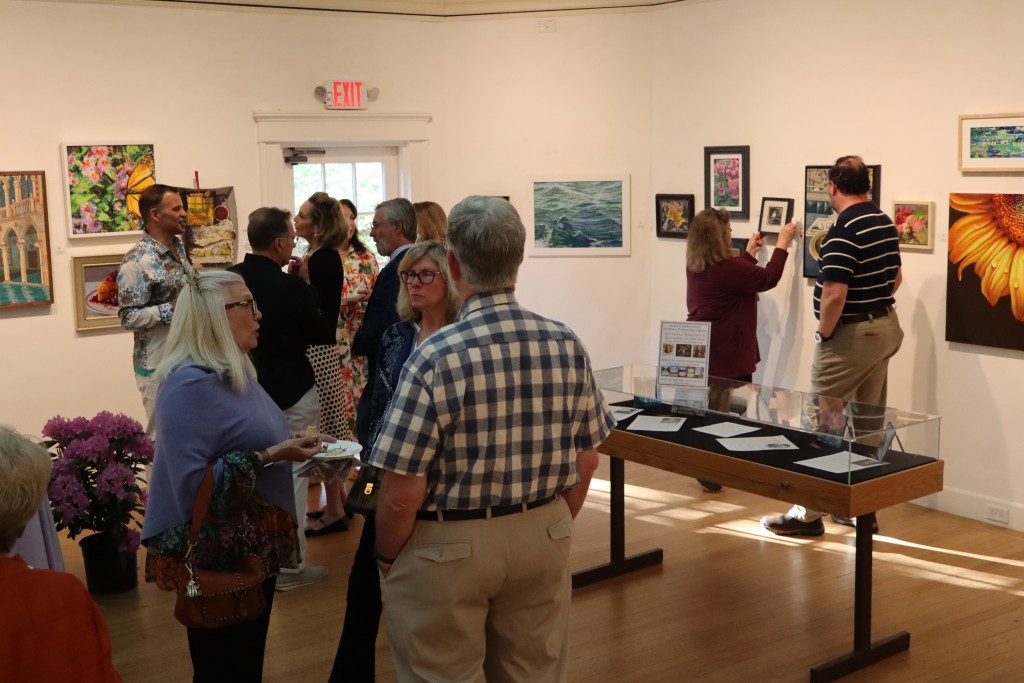 People mingle in the back gallery.