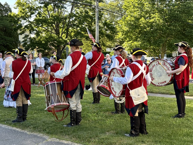 Members of the fife and drum corps with their backs to the camera