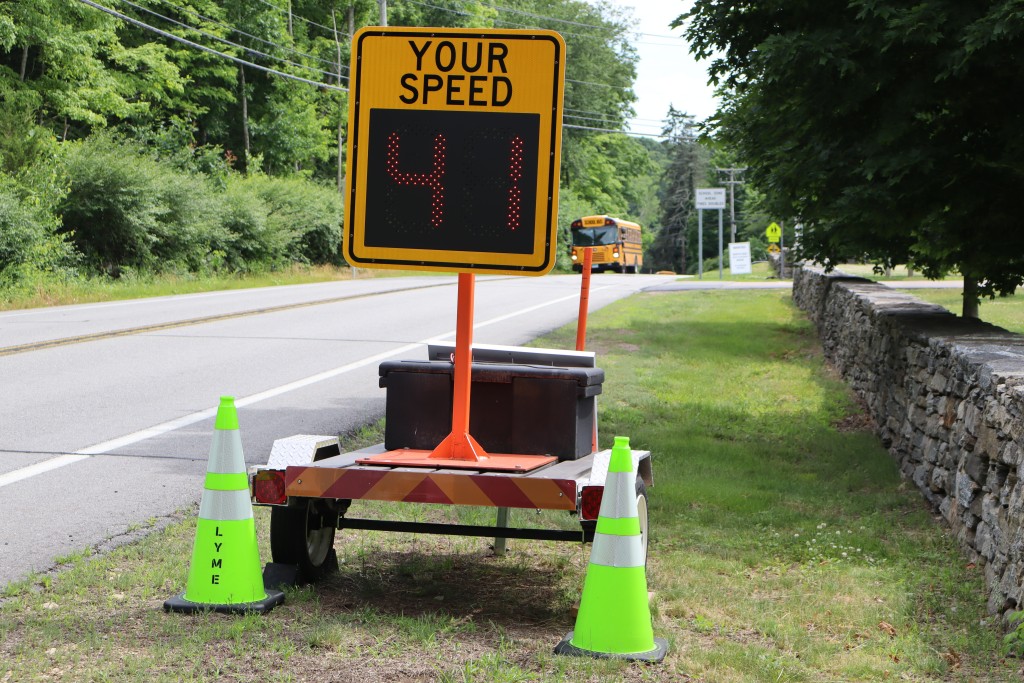 A speed sign with the words "Your Speed" shows the digital numbers 41 (triggered by an unpictured vehicle) as a bus approaches on the other side of the road.