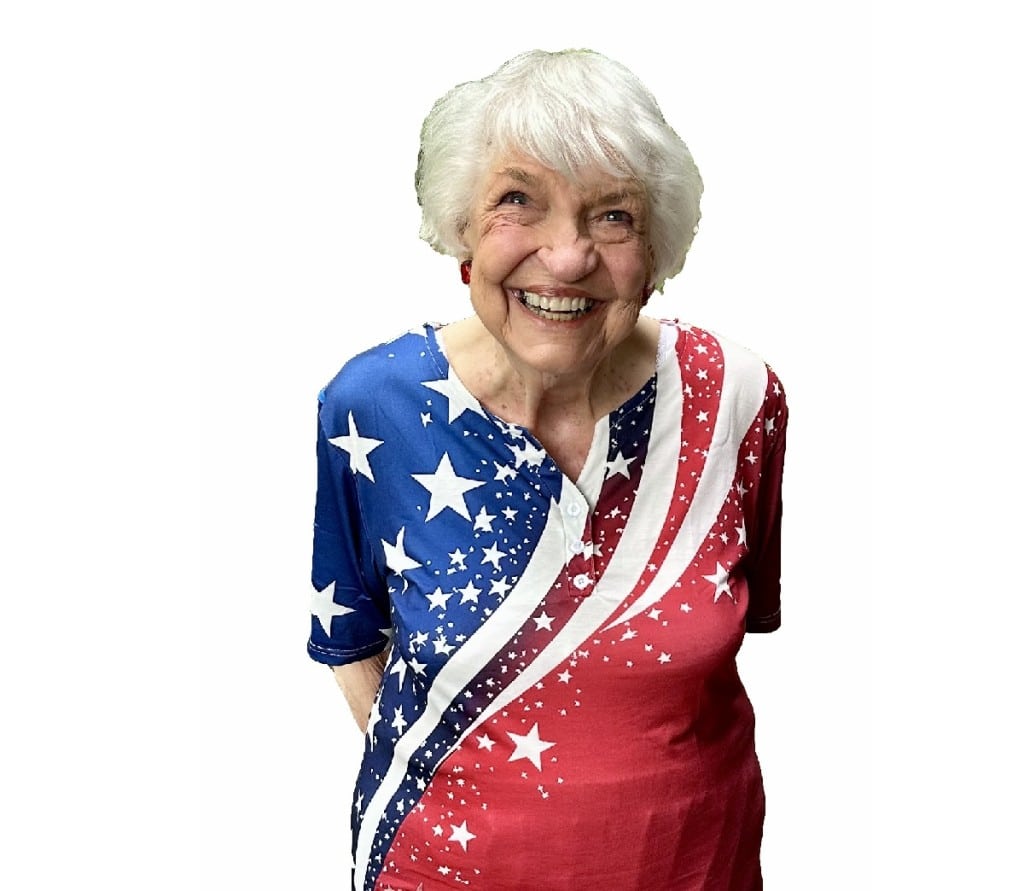 Woman with white hair in sparkly red, white and blue shirt.
